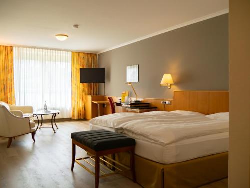 a hotel room with a bed and a table and chairs at Hotel Sonne Eintracht KG Achern in Achern
