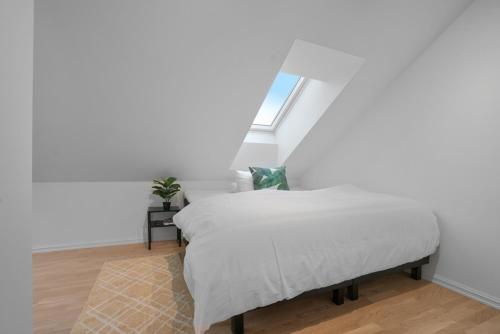 a bedroom with a white bed with a window at TotalApartments Skansegata Studio Apartments in Tromsø
