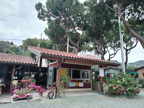 a small store with a small car parked outside at Camping Roma in Ventimiglia