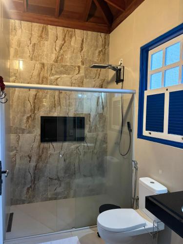 a bathroom with a shower and a toilet at Pousada Rio das Almas in Pirenópolis