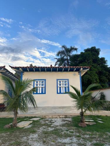 a house with two palm trees in front of it at Pousada Rio das Almas in Pirenópolis