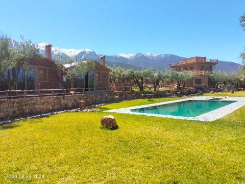 a yard with a swimming pool in front of a house at Bin Jbal Resort in Ouirgane