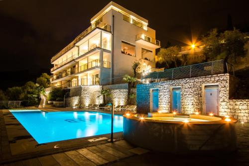 a villa with a swimming pool at night at Hotel Benacus Panoramic in Riva del Garda
