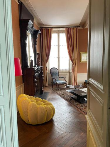 un pouf jaune posé sur le sol dans un salon dans l'établissement Le Clos de l'Ecu, à Romorantin-Lanthenay