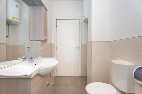 a white bathroom with a sink and a toilet at Station's Apartments Bergamo in Bergamo