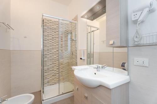 a white bathroom with a sink and a shower at Station's Apartments Bergamo in Bergamo