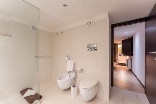 a bathroom with a toilet and a television in it at Villa Rokkaria in Villasimius