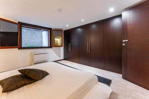 a bedroom with a large bed and wooden cabinets at Villa Rokkaria in Villasimius