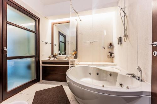 a bathroom with a large tub and a sink at Villa Rokkaria in Villasimius