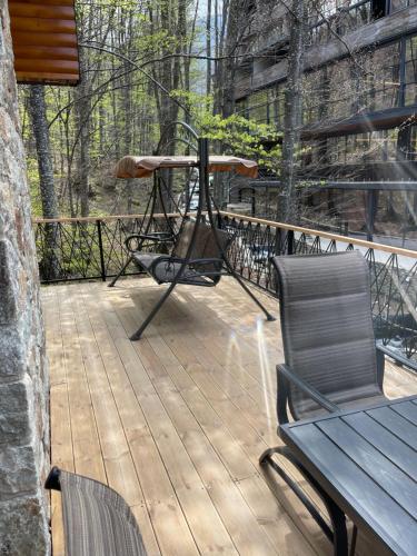 a deck with a bench and a table and chairs at Villa Noari, Brezovice. in Brezovicë