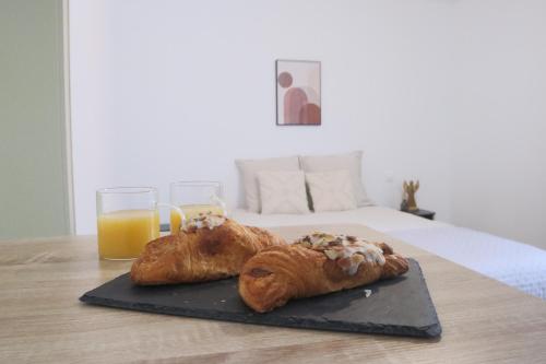 deux pâtisseries sur une table avec deux verres de jus d'orange dans l'établissement La Chambre Tantra, à Wahlbach
