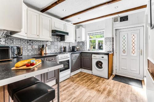 a kitchen with white cabinets and a counter top at Modern 2-Bed Home Walk to Ashby Town Centre in Ashby de la Zouch