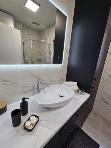 a white bathroom with a sink and a mirror at Grifone in Zadar