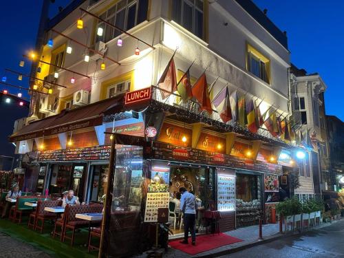 a restaurant with people standing outside of it at night at LALE SULTAN SÜİT APART in Istanbul