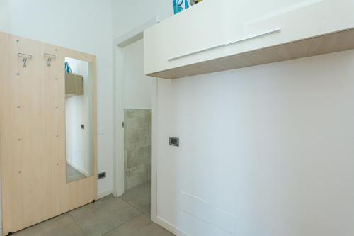 a bathroom with a white wall and a mirror at Station's Apartments Bergamo in Bergamo