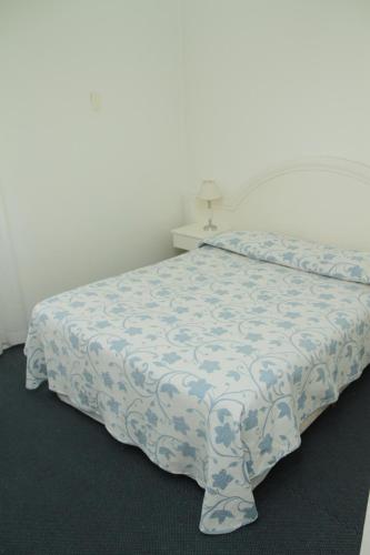 a bedroom with a bed with a blue and white bedspread at Aqua Hotel in Punta del Este