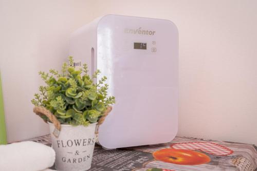 a white sewing machine sitting next to a potted plant at Station's Apartments Bergamo in Bergamo