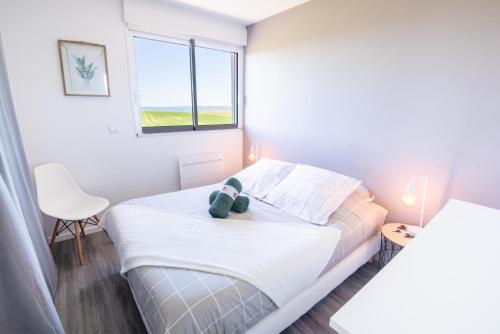 une chambre avec un lit avec un ours en peluche dessus dans l'établissement Agréable et lumineux T3 entouré de nature à 500m de la plage par Groom, à Guidel
