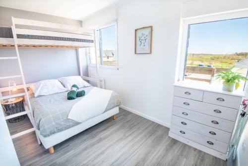 une chambre avec un lit superposé et une fenêtre dans l'établissement Agréable et lumineux T3 entouré de nature à 500m de la plage par Groom, à Guidel