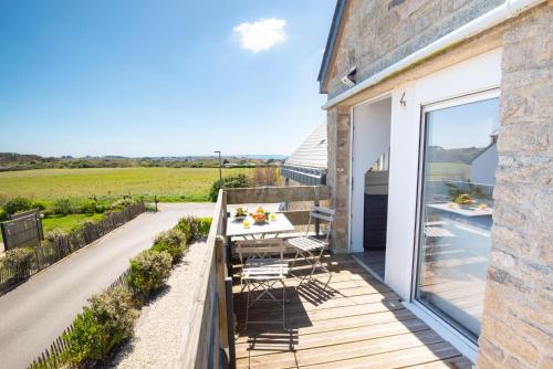 une terrasse en bois avec une table et des chaises sur une maison dans l'établissement Agréable et lumineux T3 entouré de nature à 500m de la plage par Groom, à Guidel