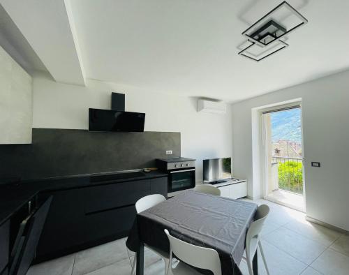 a kitchen with a black table and chairs and a window at Maison Syrah in Aosta