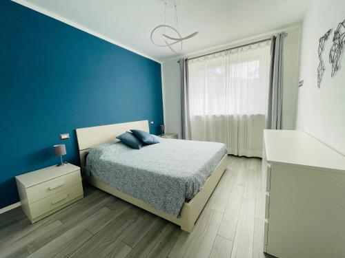 a bedroom with a bed and a blue wall at Maison Syrah in Aosta