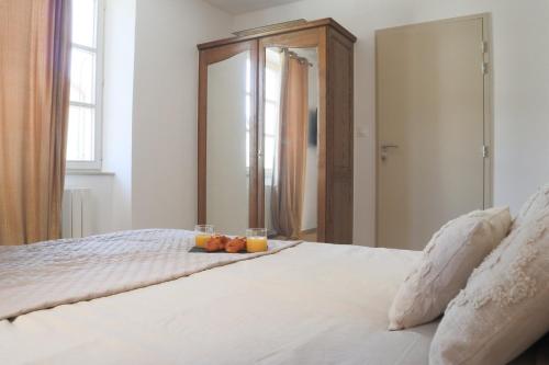 a bed with two glasses of fruit on it at La Chambre Aux Anges in Wahlbach