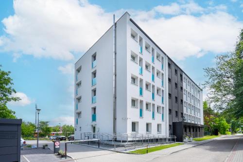 a white building with blue windows on a street at Halo Hel in Hel