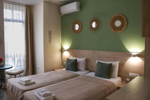 オフリドにあるZade Apartmentsの緑の壁のベッドルーム1室(ベッド2台付)