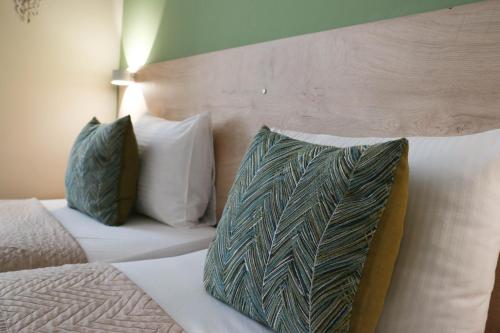 a bed with a green and white pillow on it at Zade Apartments in Ohrid