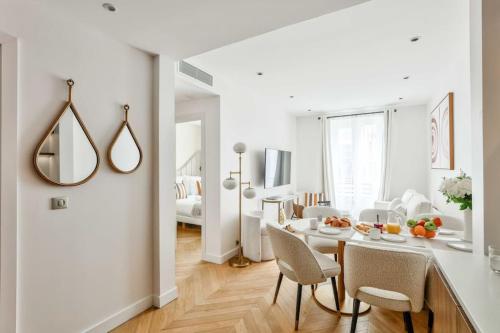 un salon blanc avec une table et des chaises dans l'établissement Magnificent Family Flat - Le Marais - with AC, à Paris