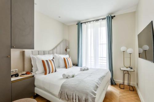 une chambre avec un grand lit blanc et une fenêtre dans l'établissement Magnificent Family Flat - Le Marais - with AC, à Paris