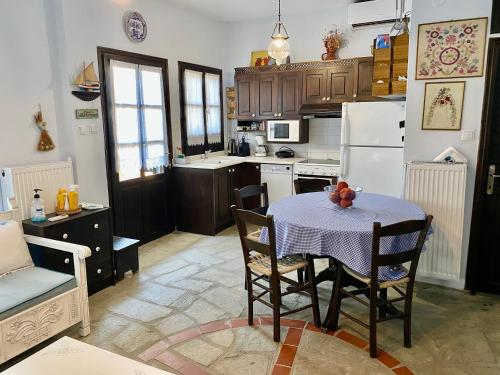 a kitchen with a table and chairs and a refrigerator at Villa Valia: Traditional Luxurious Residence in Pyrgadikia