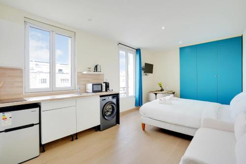 une cuisine et un salon avec un canapé et une table dans l'établissement Grand studio Aubervilliers, à Aubervilliers