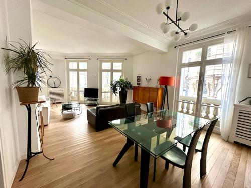 un salon avec une table en verre et un canapé dans l'établissement Grand appartement élégant - Vue Tour Eiffel, à Paris