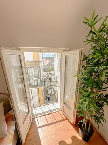 an open door to a balcony with a dog outside at Largo Inn Suites Evora in Évora