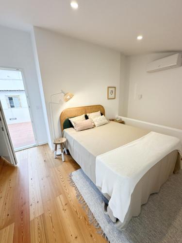 a bedroom with two beds and a large window at Largo Inn Suites Evora in Évora