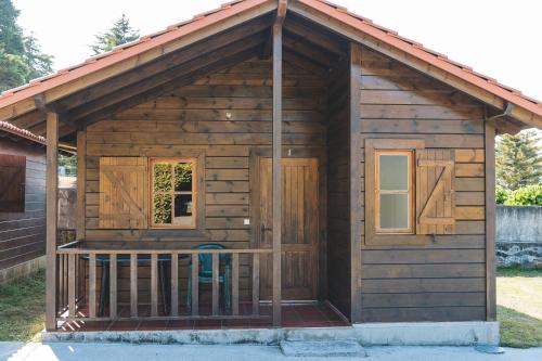 a log cabin with a porch and a balcony at Camping LagoMar in Muxia
