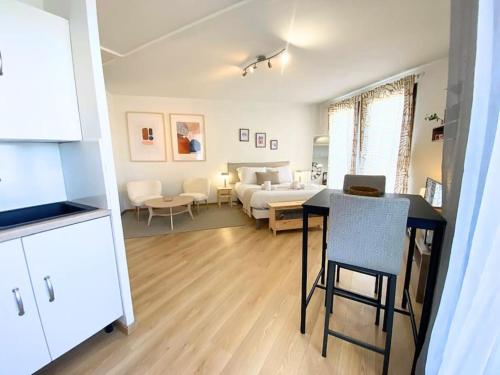 una cucina e un soggiorno con un tavolo e un divano di Balmettes - balcon, parking ad Annecy