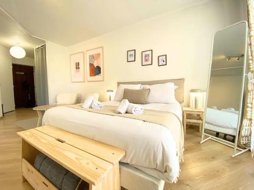 una camera da letto con un grande letto bianco e uno specchio di Balmettes - balcon, parking ad Annecy
