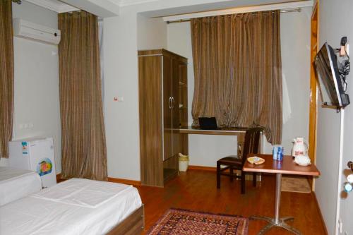 a bedroom with a bed and a table and a tableablish at Rahat Hotel in Mazari Sharif