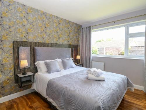 una camera da letto con un letto con due asciugamani sopra di Cedar Cottage a Norwich