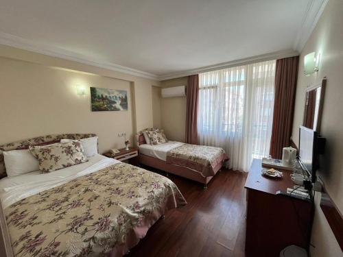 a hotel room with a bed and a television at Bayındır Palme Hotel in Antalya