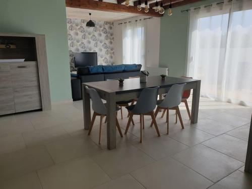 - une table à manger et des chaises dans le salon dans l'établissement Maison idéalement située à Brétignolles sur mer, à Bretignolles-sur-Mer