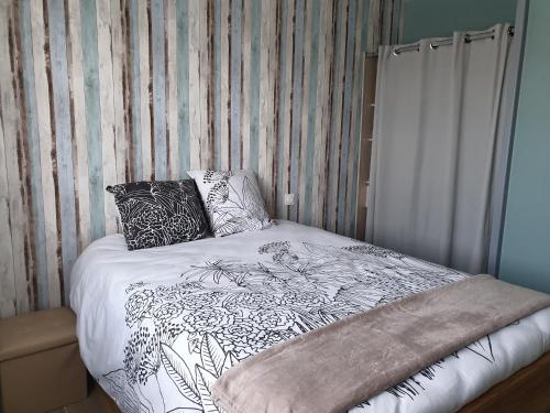 un lit avec deux oreillers dessus dans l'établissement Maison idéalement située à Brétignolles sur mer, à Bretignolles-sur-Mer