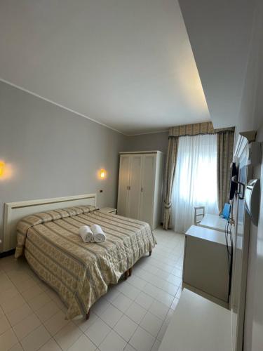 a bedroom with a bed with two towels on it at Platani Hotel in Bolsena