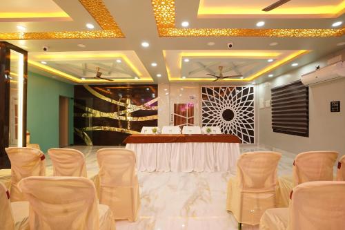a banquet hall with a table and chairs in a room at PS Luxury Hotel in Baharampur