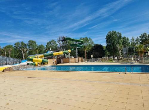 a swimming pool with a water slide at a park at Camping Valras plage 5 étoiles in Vendres-Plage