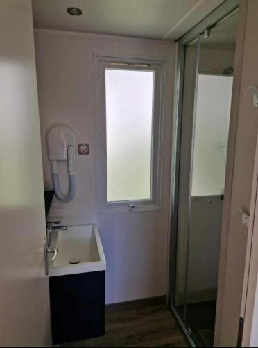La salle de bains est pourvue d'un lavabo, d'une fenêtre et d'une douche. dans l'établissement Camping Valras plage 5 étoiles, à Vendres