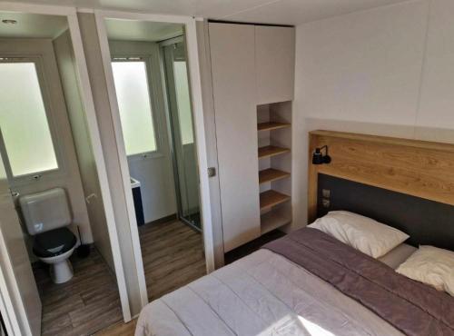 a bedroom with a bed and a bathroom with a toilet at Camping Valras plage 5 étoiles in Vendres-Plage